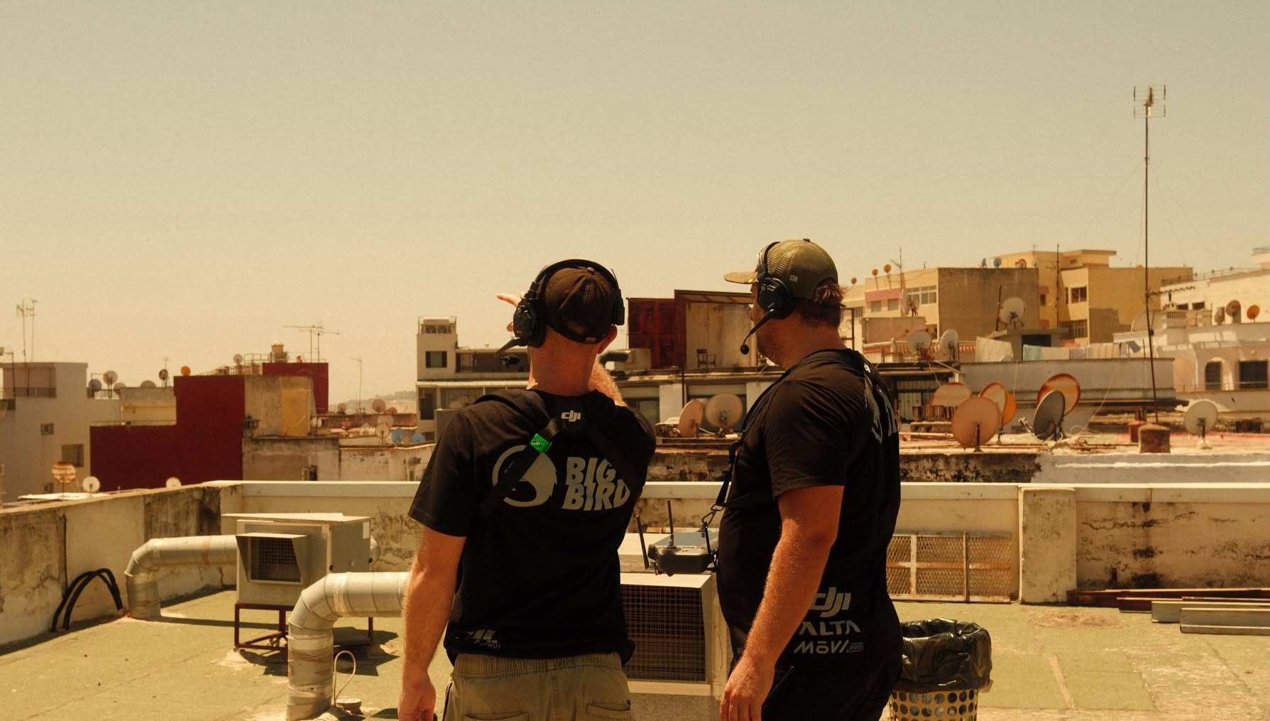 Two Big Bird crew members coordinating a rooftop shoot